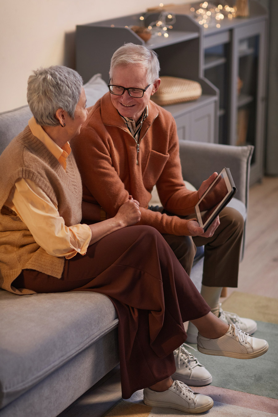 Older adults using tablet while sitting no the couch