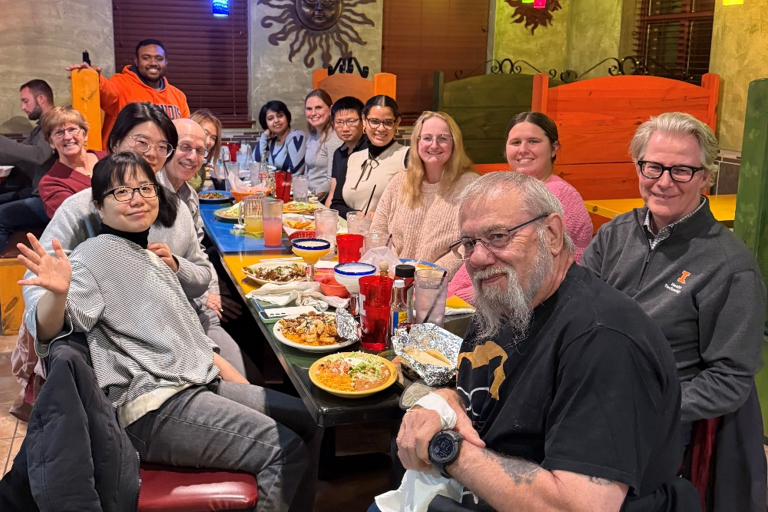 People posing for a photo at dinner table