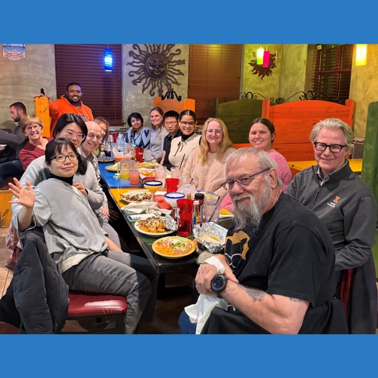 People at dinner table posing for photo