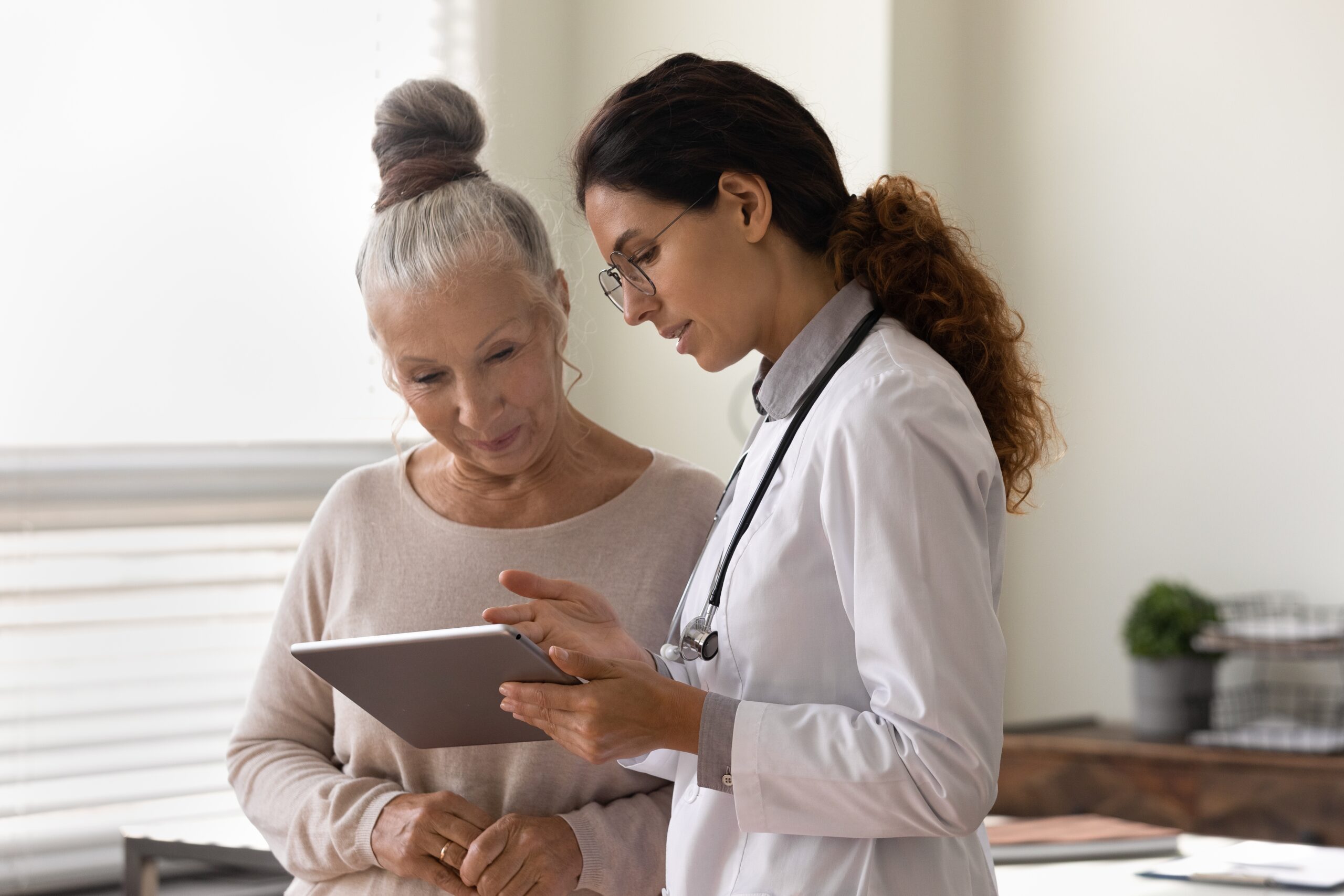 doctor and older woman with a tablet